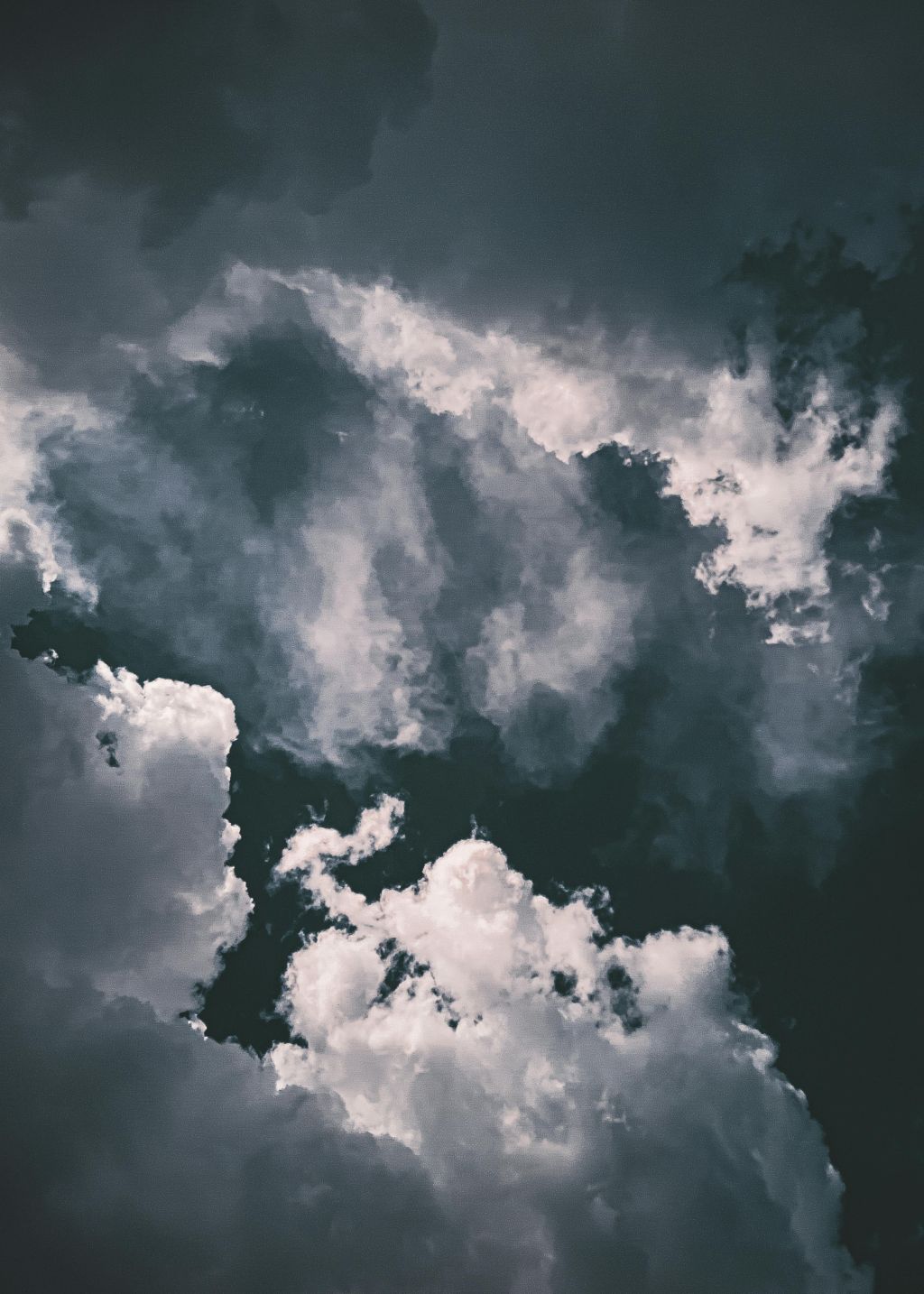 Dark, moody clouds with varying shades of gray and white fill the sky, creating a dramatic and atmospheric scene reminiscent of a La Prairie Special—where nature’s artistry meets striking overcast or stormy weather.